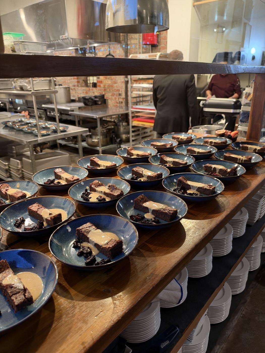 Dessert plates lined up on the pass in the Chez Bacchus kitchen